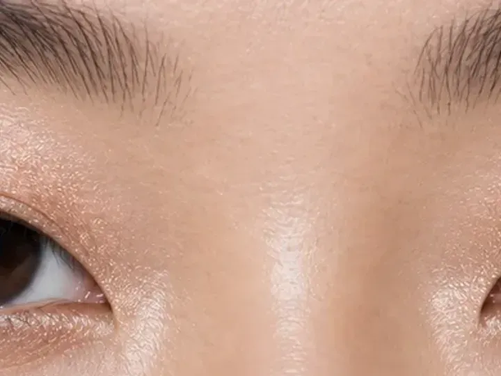 Step 2 of Soft Shimmer Makeup for Monolids, showing cocoa matte creates a soft guide at upper lash roots that remains visible with a relaxed gaze.