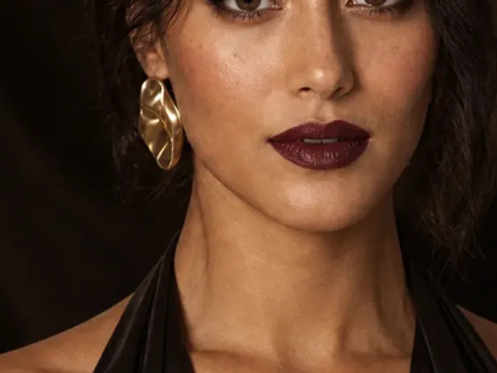 Step 6 of Elegant Dinner Party Makeup, showing muted wine is visible at upper cheek and lips while natural skin still shows through the edges.